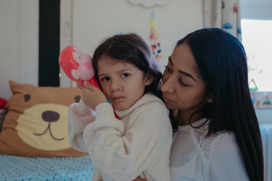 Mãe dando suporte emocional a sua filha autista em momento de crise.