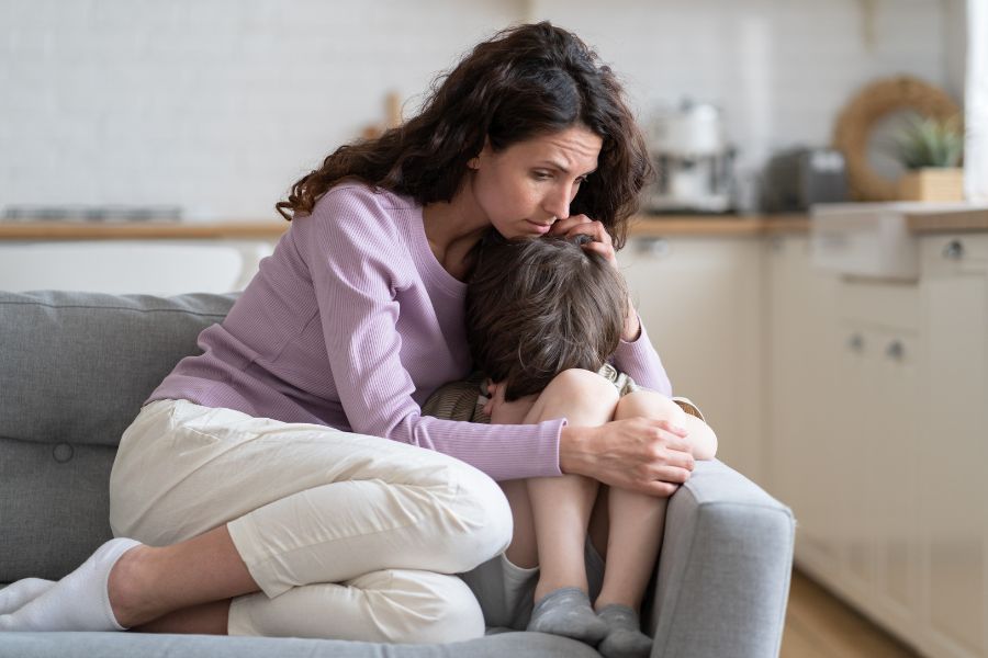 Mãe dando suporte emocial ao filho em crise causada pelo barulho.
